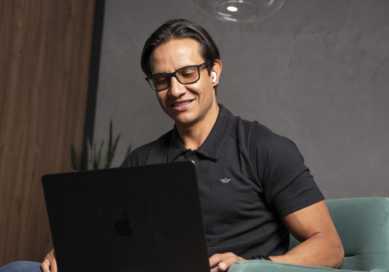 Fosdi sonriendo frente a su laptop